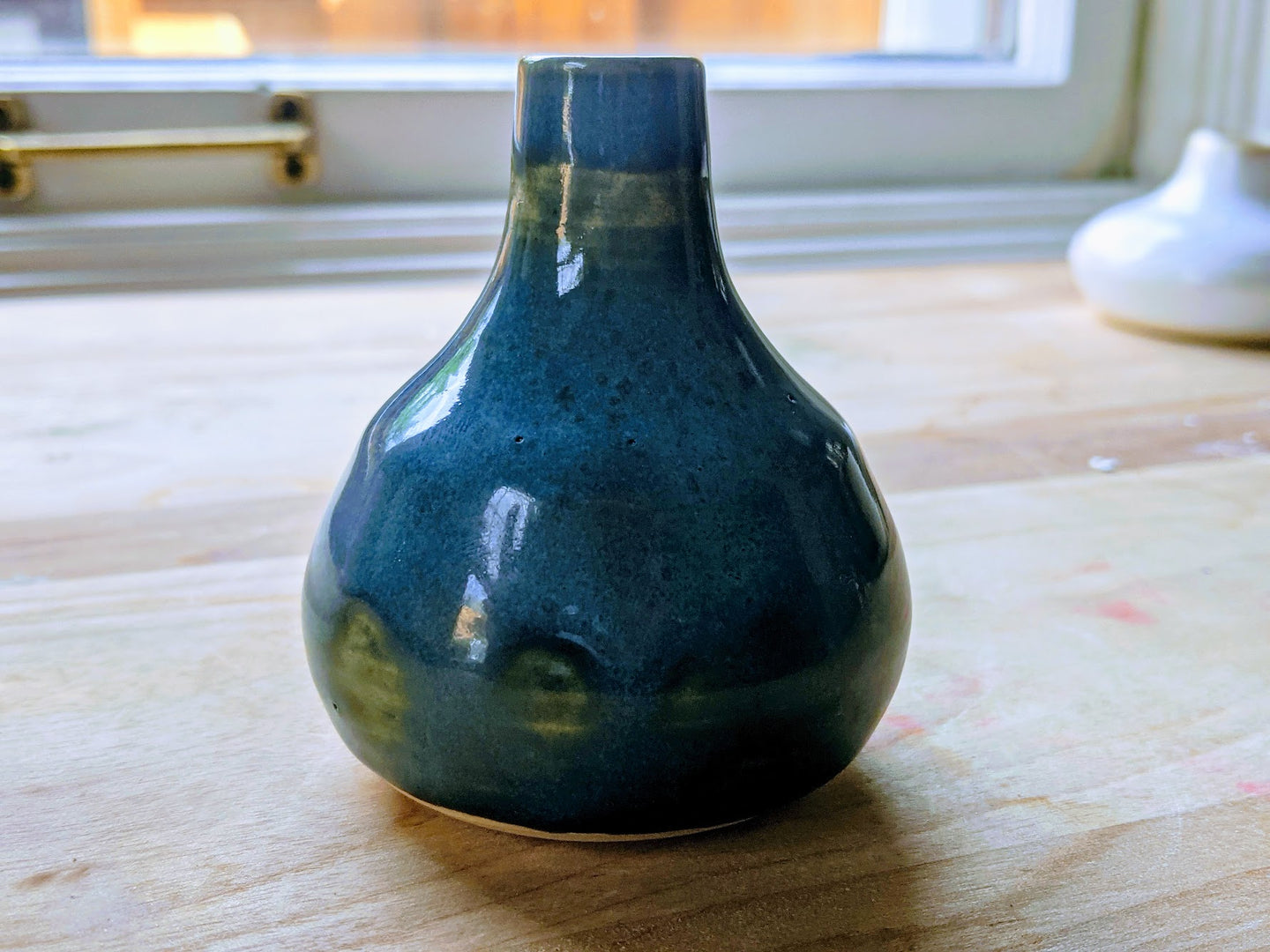 Small blue bud vase with dark green accents.